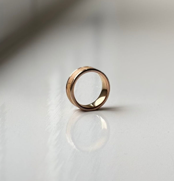 Gold ring on a reflective white surface