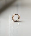 Gold ring on a reflective white surface
